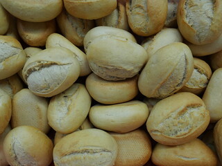 Fresh bread rolls, ready to be topped with sausage and cheese for a buffet.