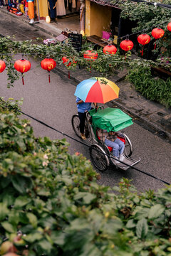 Aerial View of Festively Decorated Street in Hoi An, Vietnam with Rickshaw in Rain