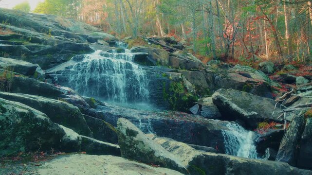 Footage captures the beauty of Glendale Falls in Berkshire County, Massachusetts, during the autumn season. The multi-tiered cascade flows over smooth granite rocks surrounded by vibrant fall foliage.