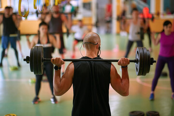 Instructor and group of people weight lifting on fitness class. Health, sport, workout concept