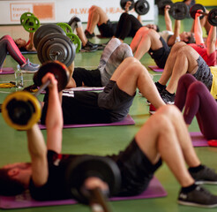 Group of people exercise with weights in fitness class. Healthy lifestyle, sport, workout concept