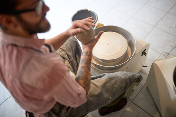 Sculptor starting to shape clay on rotate mashine in his studio. Modeling project.  Creative, hobby...