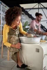Woman preparing machine for make pot from clay on pottery workshop. Creative, hobby ,activities concept