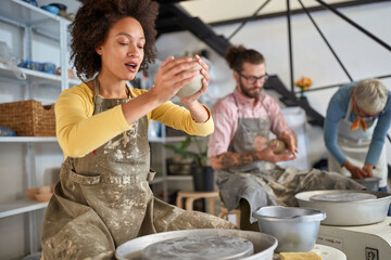Pottery workshop. Group of people and teacher modeling pot from clay.  Creative, hobby ,activities concept