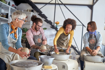 Pottery workshop. Group of people and teacher modeling pot from clay.  Creative, hobby ,activities concept