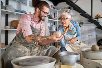 pottery workshop. beginner Making pot from clay while teacher explaining how. Creative, hobby ,activities concept