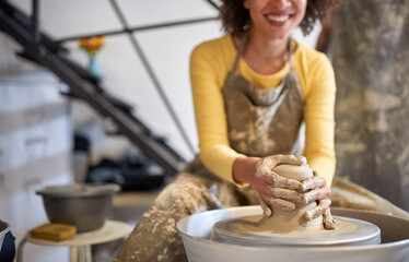 Smiling woman artist making pottery from wet clay. Business, art, hobby concept