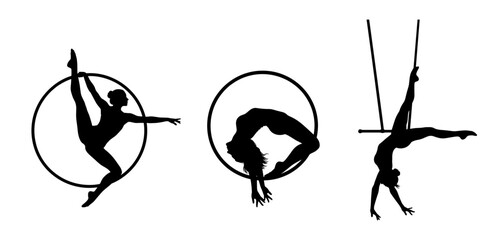 Silhouettes of aerial acrobats on hoop and pole