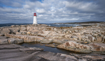 Rocky coast and lighthouse beside Atlantic Ocean at Peggy’s Cove, Nova Scotia, Canada