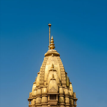 Close-up of Kashi Vishwanath Temple spire against a clear deep blue sky highlighting sharp architectural details