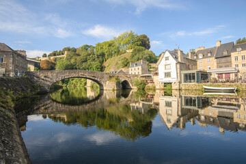 Fototapeta premium Le vieux port et vieux pont de Dinan en Bretagne et ses reflets sur la riviere de la Rance en été, departement des Côtes d'Armor