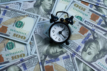 Financial Management Concept with Mini Alarm Clock on USD Bills