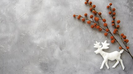 White reindeer figurine and orange berry branch on gray textured background