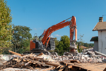 Retro-escavadora em trabalhos de demolição de uma infraestrutura antiga para posterior implantação e construção de uma nova edificação
