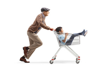 Grandfather running and pushing a boy inside a supermarket shopping cart