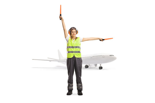 Woman aircraft marshaller signaling with wands in front of a plane