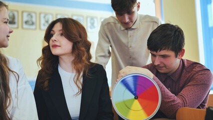 Students in physics class spin Newton's colorful wheel.
