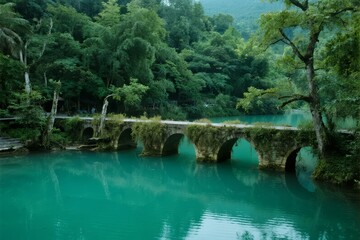 Stone arch bridge over turquoise river surrounded by lush green forest