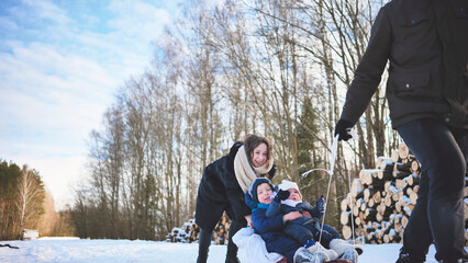 Smiling family sledding down snow covered hill, sharing laughter and winter excitement during outdoor recreational moment