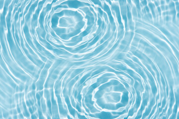 Blue water with ripples on the surface. Defocus blurred transparent blue colored clear calm water surface texture with splashes and bubbles. Water waves with shining pattern texture background.