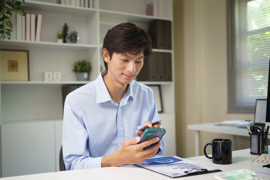 Professional bookkeeper checking financial information on his phone.
