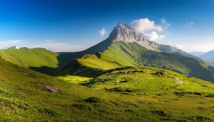Fototapeta premium mountain peak rising above a green valley sunny landscape
