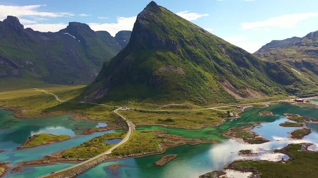Pullback aerial shot of Volandstind summit and the iconic bridges in Fredvang, Lofoten Archipelago