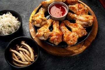 Baked chicken wings in asian style with sauces.