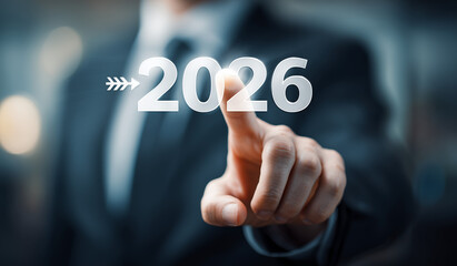 Fototapeta premium Businessman Touching 2026 on Virtual Interface. Close-up of a businessman in a suit touching the year 2026 on a transparent virtual interface. Planning, business strategy, trends, growth, leadership 