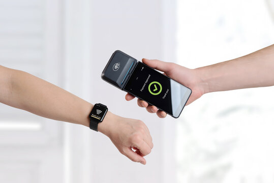 Smartwatch contactless payment approved on mobile POS terminal, showing modern wearable technology and fast digital checkout experience
