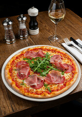 Frische Pizza mit Schinken, Salami und Rucola