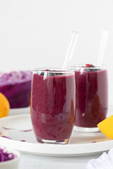 Red cabbage berry lemon smoothie on kitchen table with white background. Close-up. Copy space. Healthy detox blended drink.