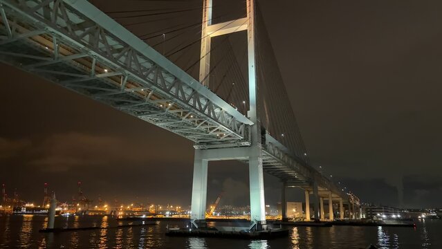 Yokohama Bay Bridge and illuminated Yokohama Port skyline at night seen from a ferry
 - Powered by Adobe