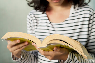 Girl Focus on Reading  with Worn Yellow Paperback
