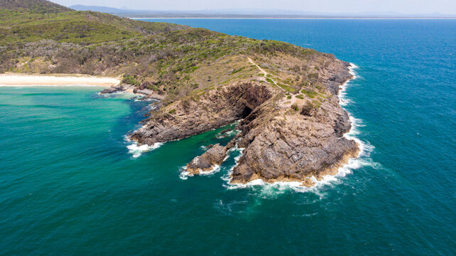 Aerial view of Hell's Gates with the rugged cliffs meeting the turquoise ocean, the lush green vegetation contrasting with the rocky terrain, Noosa Heads, Queensland, Australia.