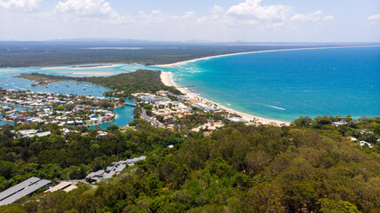 Aerial view of turquoise waters meet sandy beaches and lush green headland, a stunning coastal panorama unfolds, Noosa Heads, Queensland, Australia.