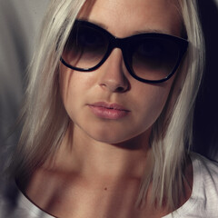 Blonde Woman Wearing Sunglasses With Shadows on Her Face Indoors