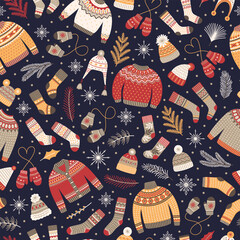Seamless pattern with cozy winter knitted clothes. Christmas background with sweaters, socks, hats, and mittens on dark blue. Vector illustration.