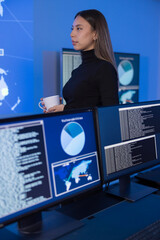 Female analyst monitoring data in a SOC environment with multiple screens