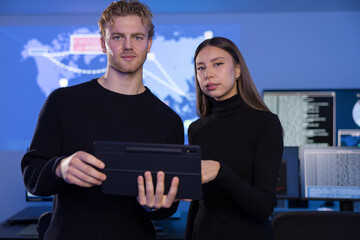 Analysts using tablet in SOC conducts collaborative cybersecurity monitoring