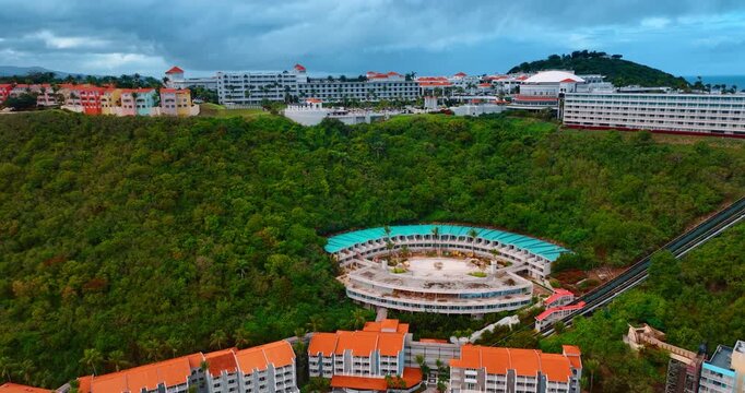 Stunning far eastern tip of Puerto Rico with beautiful green hills. Range of modern buildings in the hotel territory. Grey clouds at backdrop.