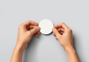 Hands sticking white round sticker, grey background, ai generated