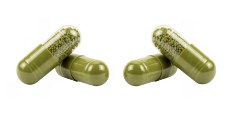 Green capsules with small pellets inside on black pills supplements isolated on a transparent background