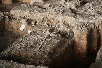 Archaeological excavations. Human remains in the ground, with many artefacts found in the tomb. Real digger process. Outdoors at Ban Pong Manao Archeological Site, Lopburi, Thailand.