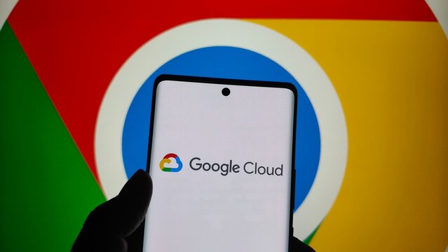 Smartphone displaying google cloud logo in front of the google chrome browser icon background, technology concept  , New York City, 15 December 2025