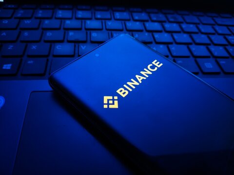 Binance cryptocurrency logo on a laptop keyboard in blue light