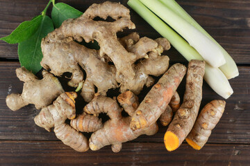 Fresh turmeric, ginger, and lemongrass on wooden plank background. Top view. copy space