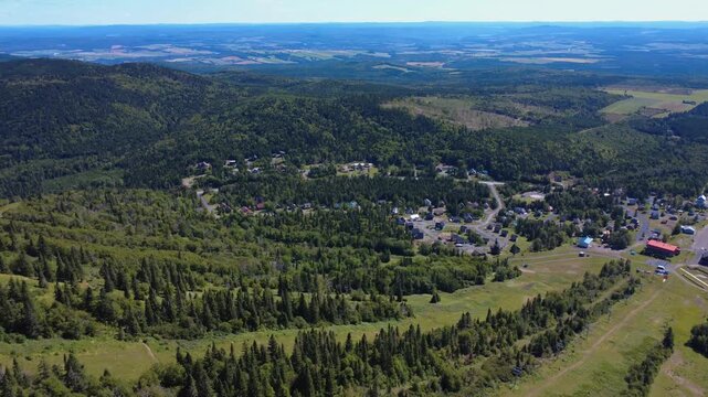 Panoramic aerial view above Val d'Irene Regional Park and its hamlet surrounded by the forest located in the heart of the Matapedia Valley, Sainte-Irene, Quebec, Canada, 2025.