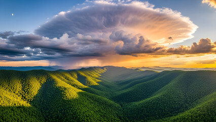Dramatic supercell thunderstorm cloud formation over lush green mountain range at sunset