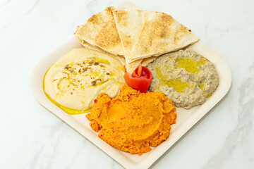 A gourmet version of hummus with high-quality sesame tahini, garnished with toasted pine nuts, mint, and a squeeze of fresh lemon juice